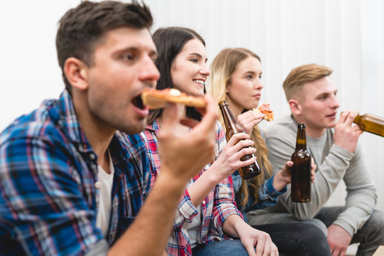 The four people on the sofa eat pizza and drink a beer on the white background