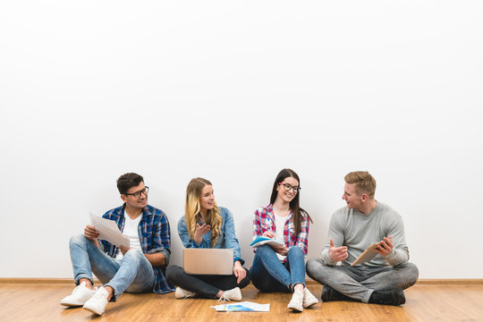 The Four People Sit On The Floor On The White Background