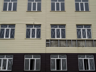 Wall of an abandoned building. Modern building. Grunge urban background. Unfinished building. WIndows