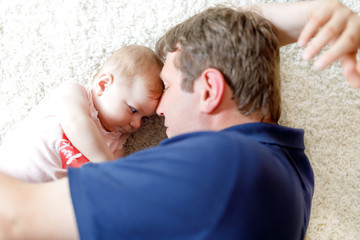 Happy proud young father with newborn baby daughter, family portrait togehter
