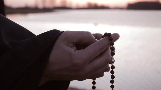 The hand of the priest plucked the rosary in prayer 2