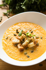 Pumpkin soup on wood table with pupkin seeds