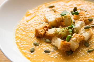 Closeup to pumkin soup with bread