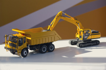 Model of a truck and an excavator on the stand. Industry