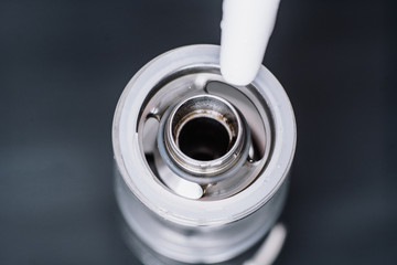 Macro shot of fueling a vape smoking an electronic cigarette, runs vape juice electronic cigarette....