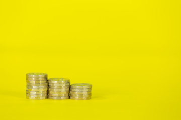 Stacks of Pound Coins on a Yellow Background