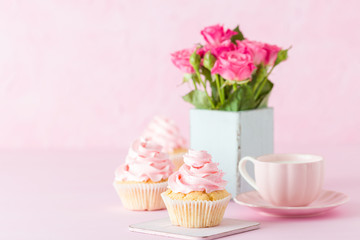 Pink pastel horisontal banner with decorated cupcakes, cup of coffe with milk and bouquet of pink roses.