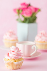Pink pastel vertical banner with decorated cupcakes, cup of coffe with milk and bouquet of pink roses.