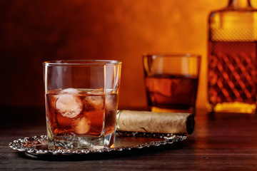 Glass of  whiskey and cigar on old wooden table.