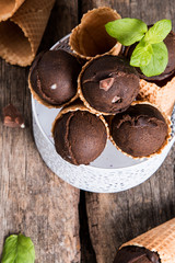 Ice cream, Chocolate ice cream scoop in waffle cone on wooden background.