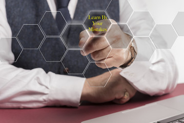 A smartly dressed business man sitting at a desk whilst pushing a virtual button on the screen...