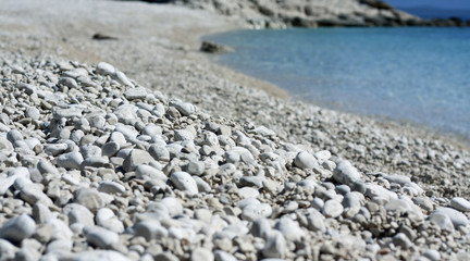 Fototapeta na wymiar White pebbles beach and blue sea. Low angle view