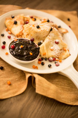 White pan with pancakes and fresh berries