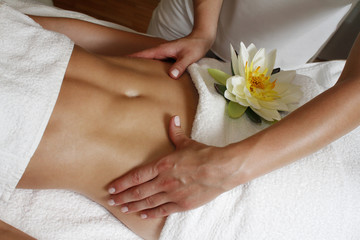Obraz na płótnie Canvas Woman relaxation massage in therapy wellness with lotus flower