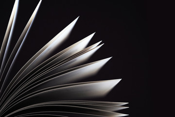 Black and white. Macro view of book pages. Concept of open book, white sheets on dark black...