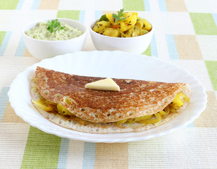 Masala dosa, a south Indian vegetarian, traditional and popular crepe, with a filling of a mixture of mashed potatoes and fried onions and with a butter topping, is known globally.