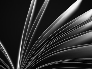 Macro view of book pages. Black and white. Concept of open book, white sheets on dark black ...