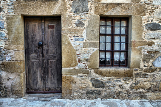 old wooden door and window on stone building