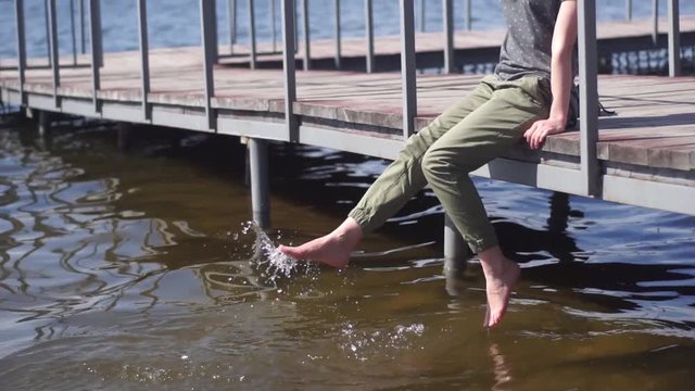 Girl wet foots in lake in slow motion