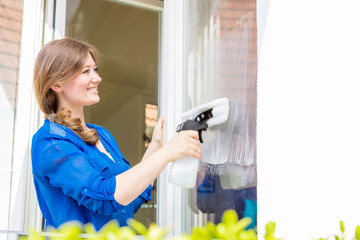 Frühjahrsputz (frau putzt fenster in eigenem zuhause )