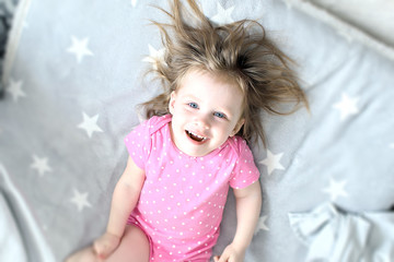 Happy little girl in bed at home