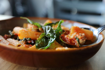 Pasta with sausage in tomato sauce on wood background , italian food