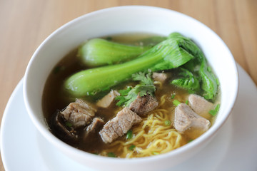 Chinese noodles with pork on wood background