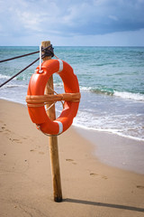 Rettungsring an Holzpfahl am Meer