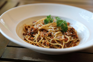 spaghetti Bolognese with minced beef and tomato sauce garnished with parmesan cheese and basil , Italian food