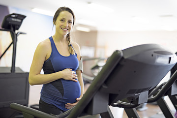 Pregnant woman is doing exercises at the gym