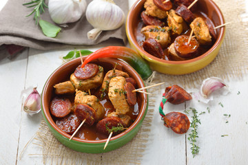 Spanische Pinchos: Geschmorte Schweinefilet-Stückchen mit angebratener scharfer Chorizo Paprikasalami serviert – Spanish snack: Braised pork fillet with fried slices of chorizo paprika sausage