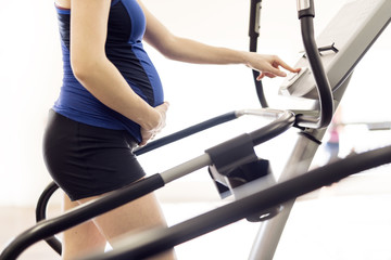 Pregnant woman is doing exercises at the gym