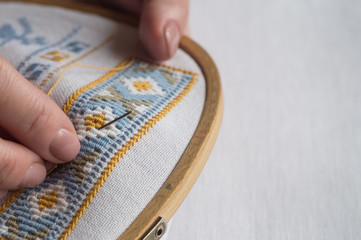 Woman's hands embroider ornaments