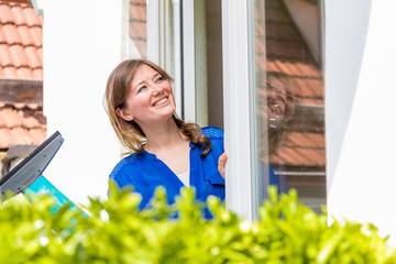 Frühjahrsputz (frau putzt fenster in eigenem zuhause )