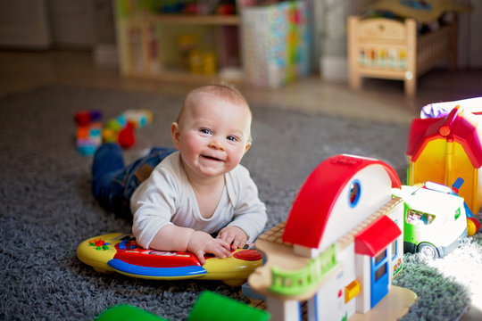 Cute baby toddler boy, playing with lots of colorful construction toys