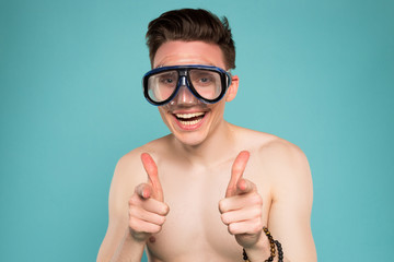 Being funny is one of the greatest strengths! Closeup portrait of the young smiling man in goggles on the summer vacation.