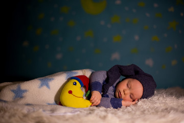 Little baby boy with cute teddy bear and moon on a blue star and moon background