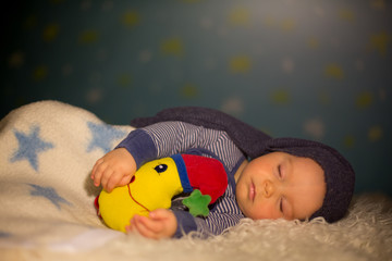 Little baby boy with cute teddy bear and moon on a blue star and moon background