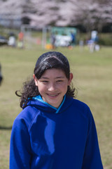 Teenage girl at park exhibiting joy and happiness on a sunny day.