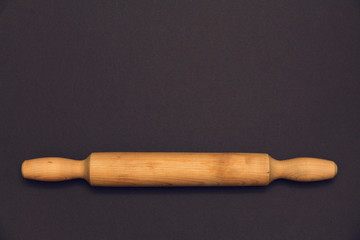 Rolling pin  on a dark background. Free space for text