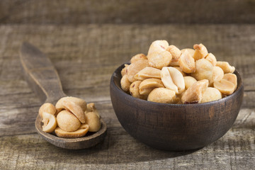 Toasted peanuts on wooden background - Arachis hypogaea