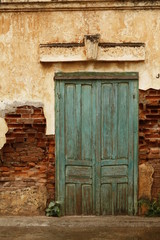 street view detail of exterior of dilapidated french colonial buildings in Laos, Southeast Asia