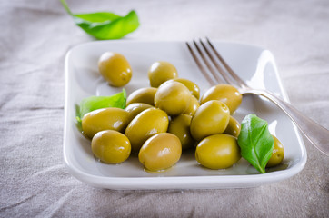 Green olives on a white plate