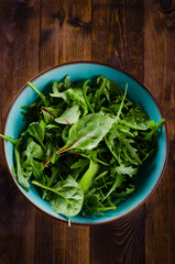 Fresh green salad with spinach,arugula, mangold and lettuce on dark wooden background