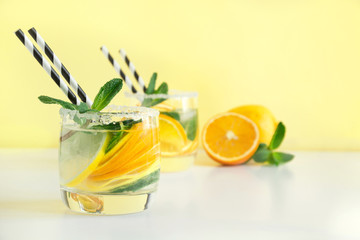 Fototapeta premium Fresh summer lemonade with citrus, orange and mint on yellow background.