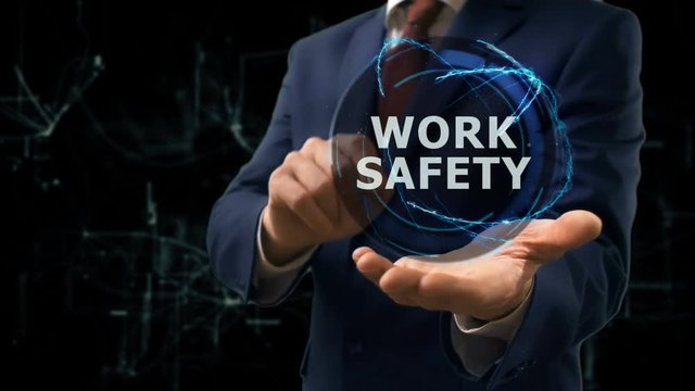 Businessman shows concept hologram Work safety on his hand. Man in business suit with future technology screen and modern cosmic background