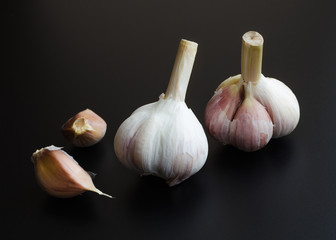 heads of garlic over black
