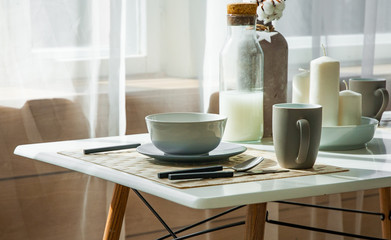 Wooden table with cup and dish in modern dinning room at home. Interior of dinning room at home.