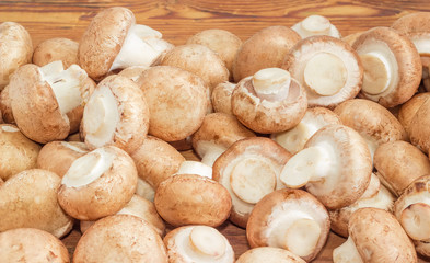 Pile of the raw brown mushrooms on wooden surface