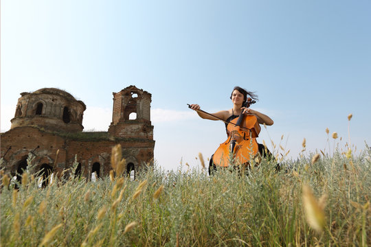 The beautiful girl plays a violoncello